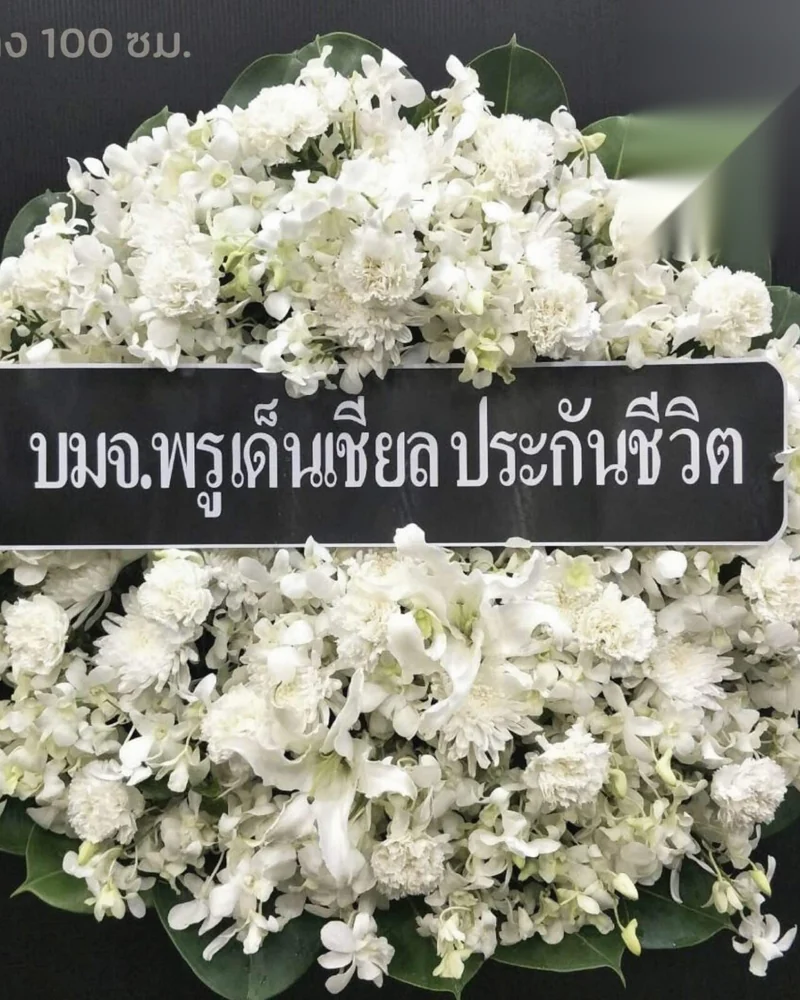 พวงหรีดดอกไม้สดตั้งเรียงบนขาตั้งด้านหน้าศาลาวัด
