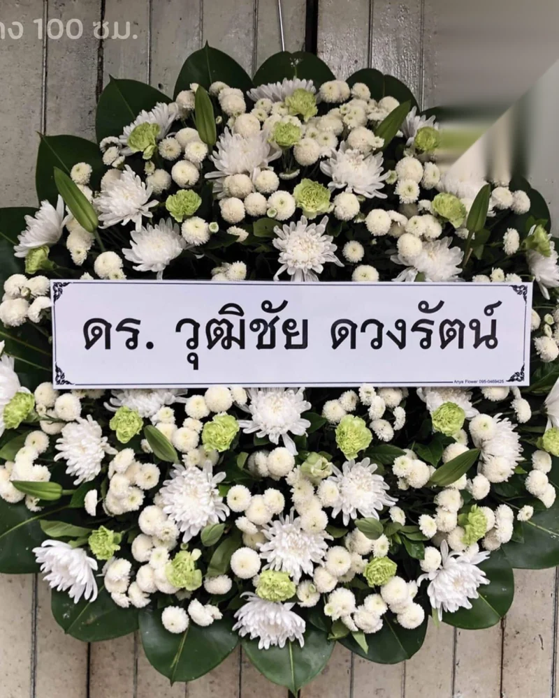 พวงหรีดดอกเบญจมาศสีขาวที่จัดอย่างเรียบร้อยสำหรับพิธีไว้อาลัย