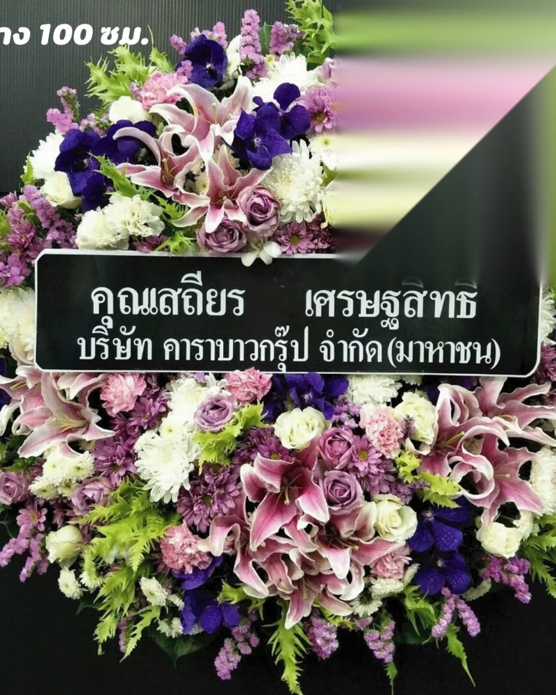 พวงหรีดดอกไม้สดโทนม่วงตั้งอยู่หน้าศาลา