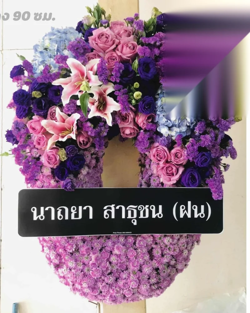 พวงหรีดดอกไม้สดหลายพวงตั้งต่อเนื่องหน้าศาลา