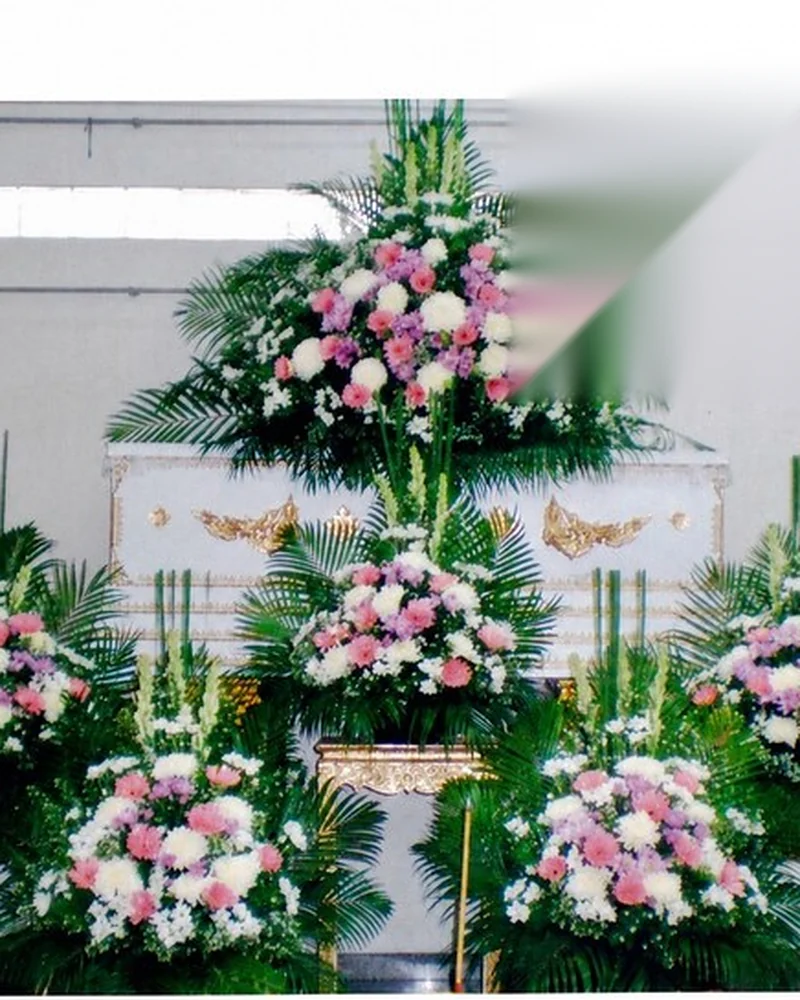 ดอกไม้สีขาวจัดขนาบสองข้างหีบศพในพิธีไว้อาลัย