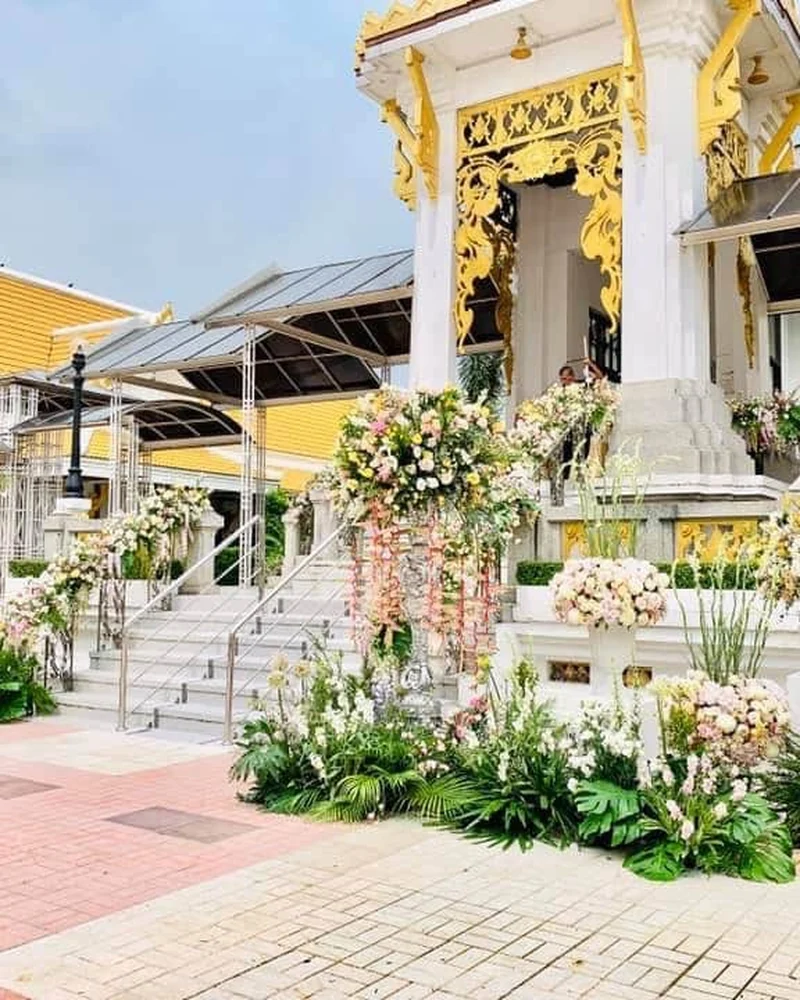 ดอกไม้หลากสีเหลืองชมพูขาวจัดเป็นช่อใหญ่ประดับหน้าอาคารสีทอง