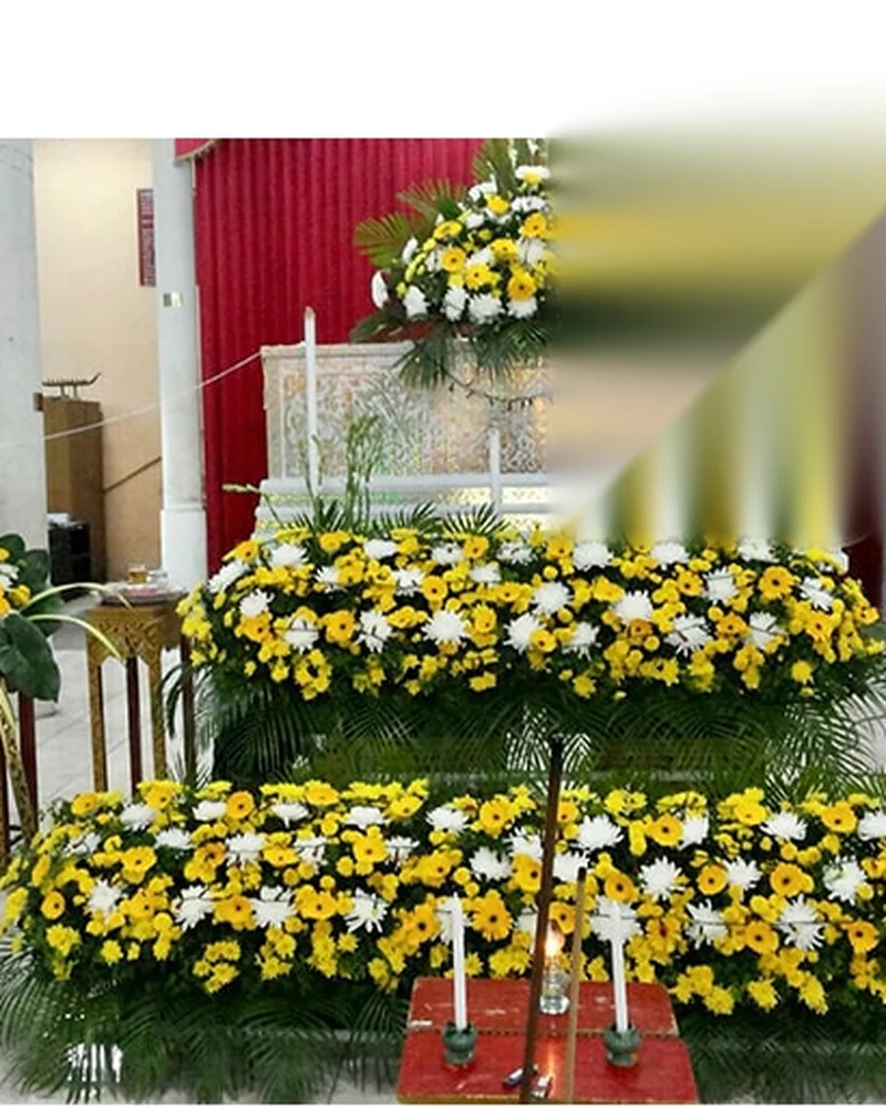 ดอกไม้สีเหลืองขาวจัดประดับหน้าโลงในพิธีไว้อาลัย