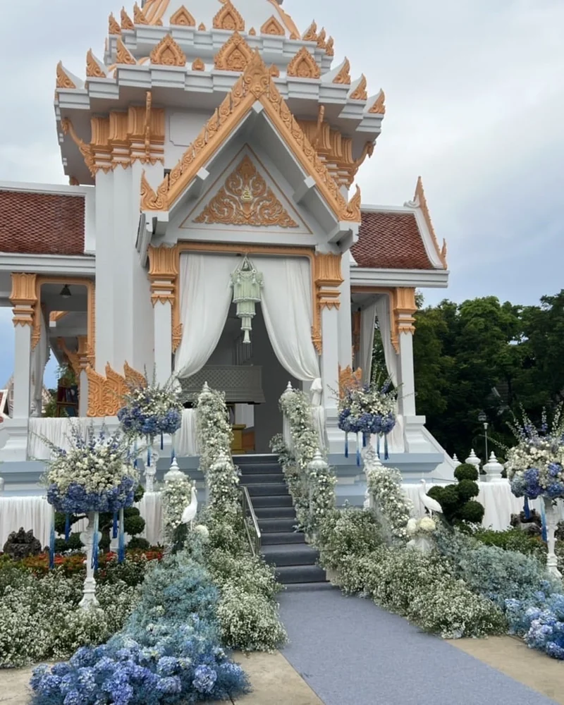 พวงดอกไม้โทนม่วงขาวแขวนเสาทางเดินขึ้นศาลาสวดพระอภิธรรม