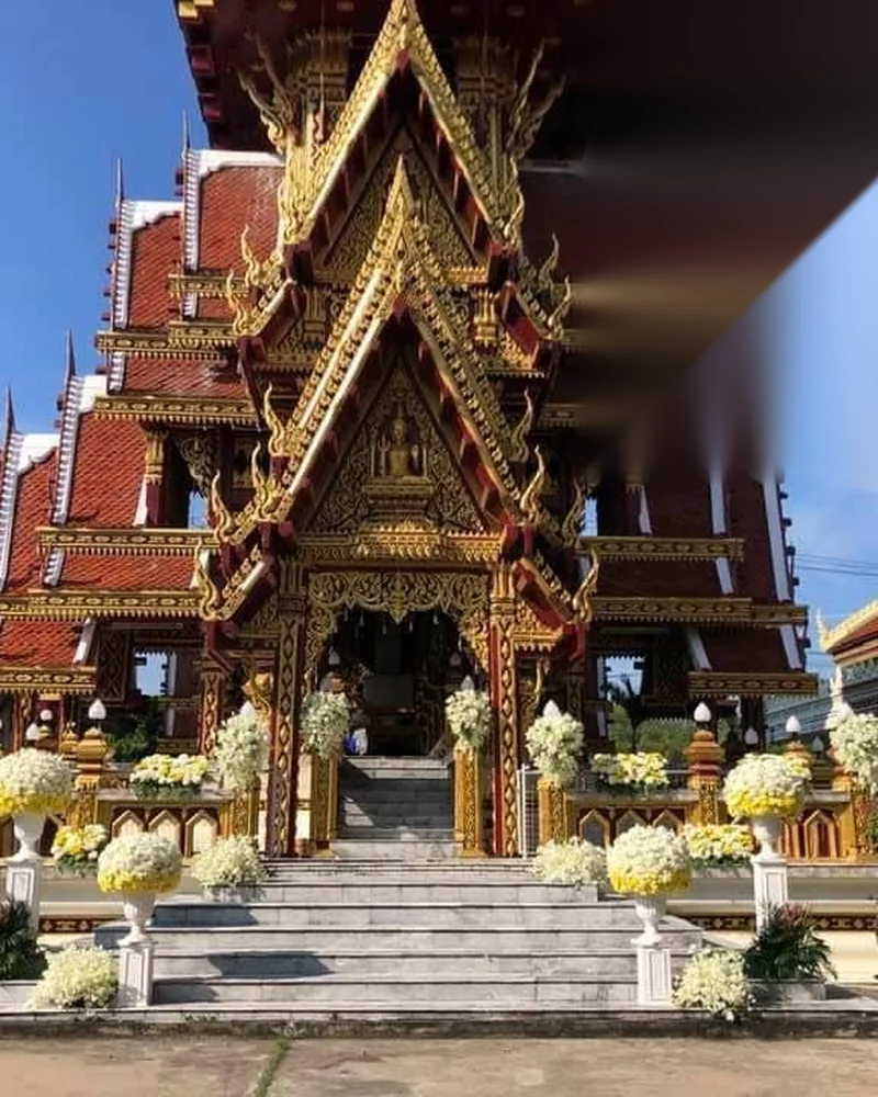 ศาลาทรงไทยหลังคาแดงทองประดับลวดลายวิจิตรมีพวงหรีดดอกไม้เหลืองขาวหน้าบันได
