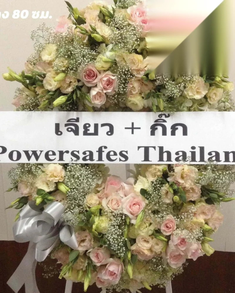 พวงหรีดดอกไม้โทนชมพูครีมพร้อมป้ายชื่อผู้ส่งและบริษัทที่ฝากสั่ง