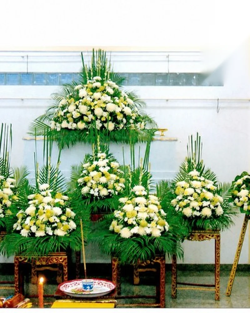 ดอกไม้สีขาวเหลืองจัดทรงเจดีย์หลายชั้นประดับหน้าโลงศพ