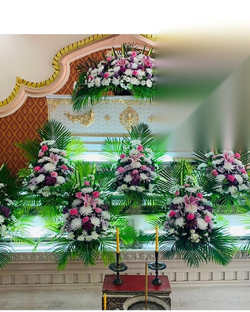 ดอกไม้โทนชมพูม่วงประดับขั้นบันไดหน้าโลงศพในงานพิธีภาคค่ำ